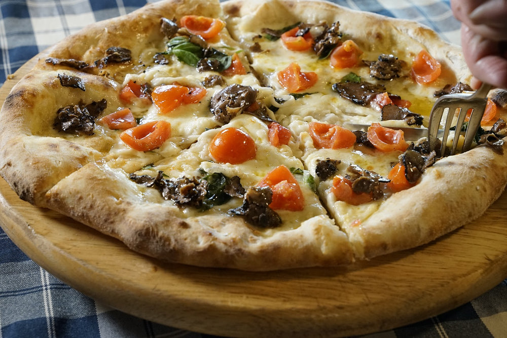 Pizza with summer truffle slices and pachino tomatoes